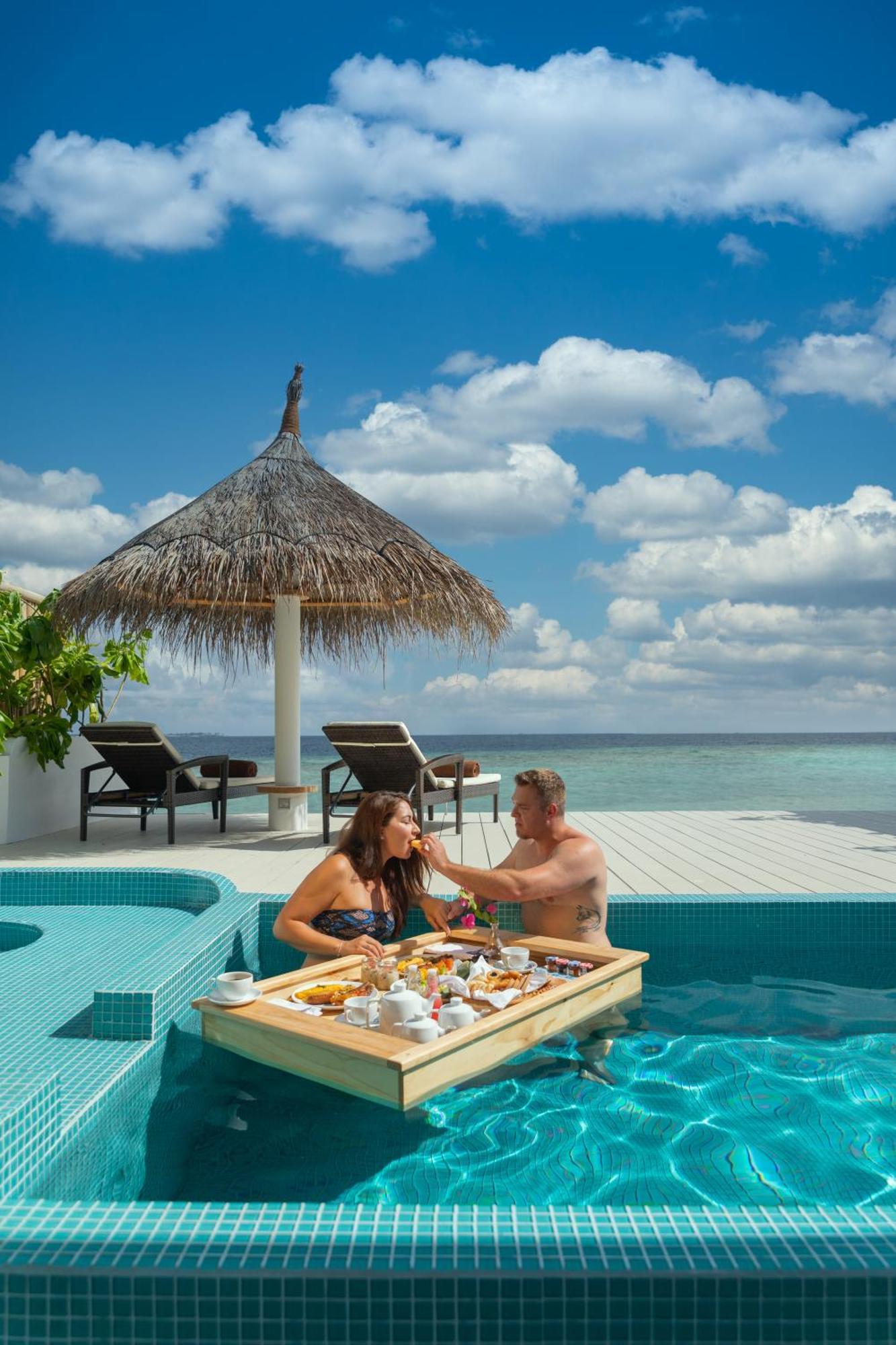 Malahini Kuda Bandos Resort Hulhumale Esterno foto A couple dining at the pool of a resort in Maldives